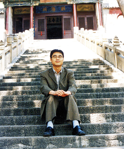 Journalisten Shi Tao sitter i en trapp.