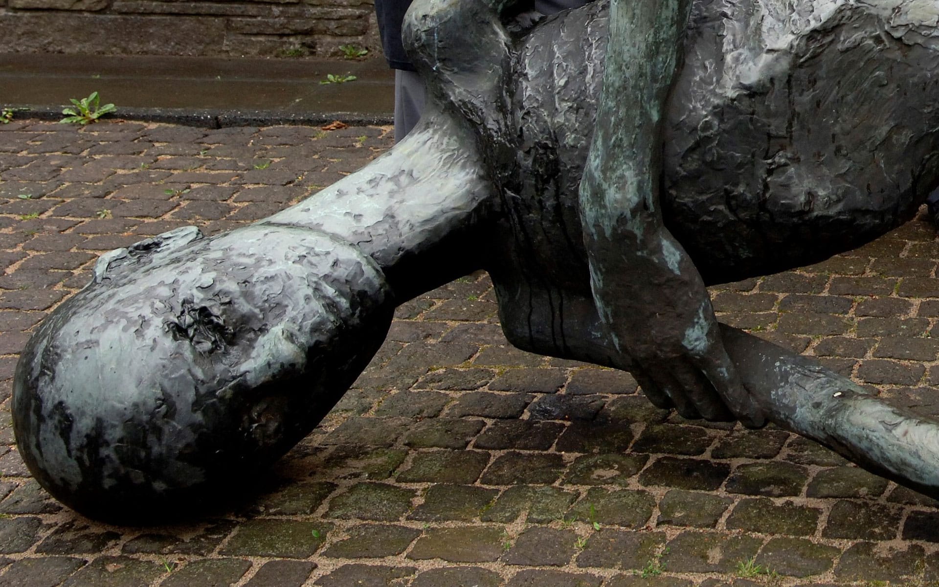 Menneskestatue som ligger på bakken