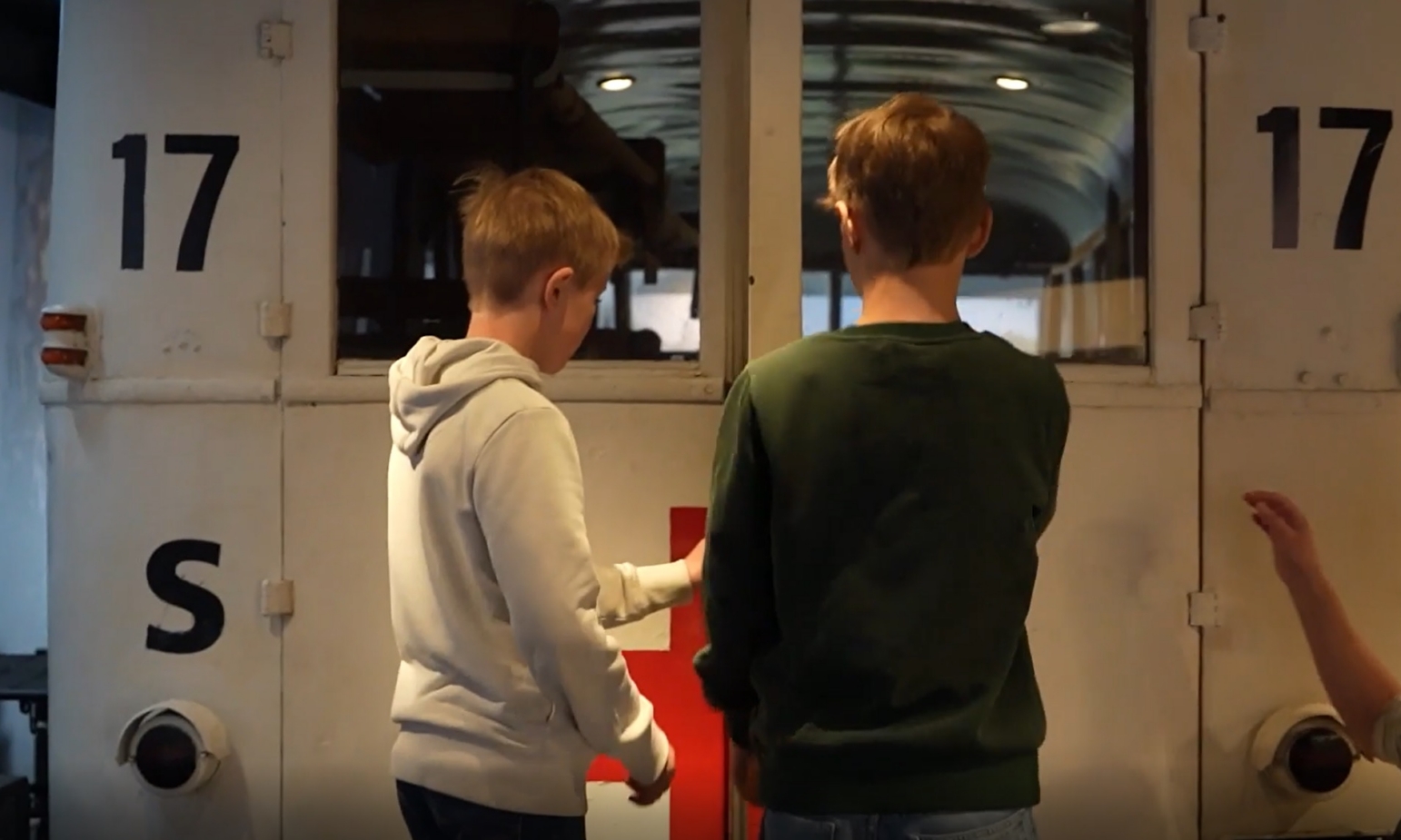To unge gutter sett bakfra på vei inn bakdøren i en hvit buss.