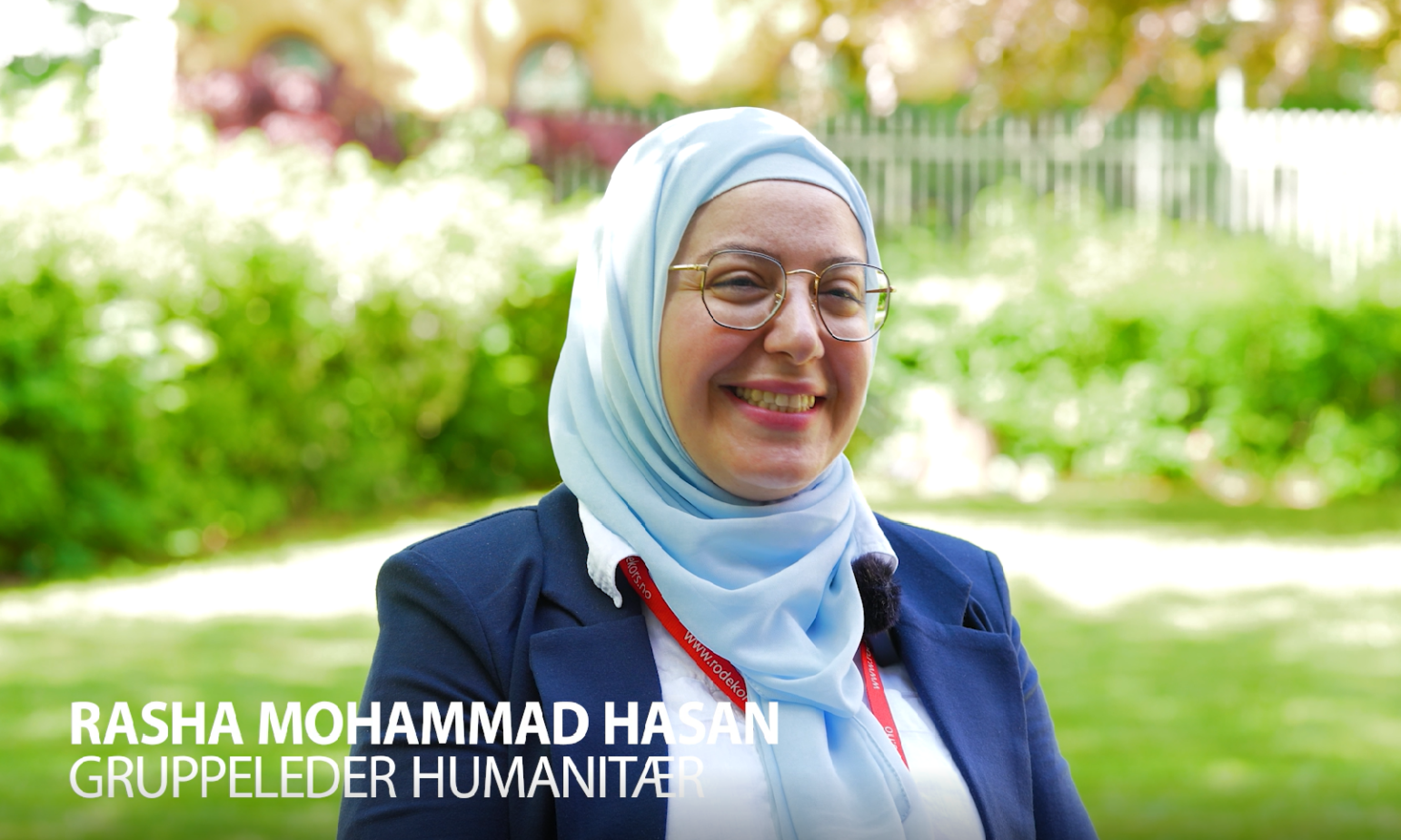 En ung kvinne i blå blazer og lys blå hijab som smiler mot kamera. Ved siden av vises teksten: "Rasha Mohammad Hasan, Gruppeleder humanitær"